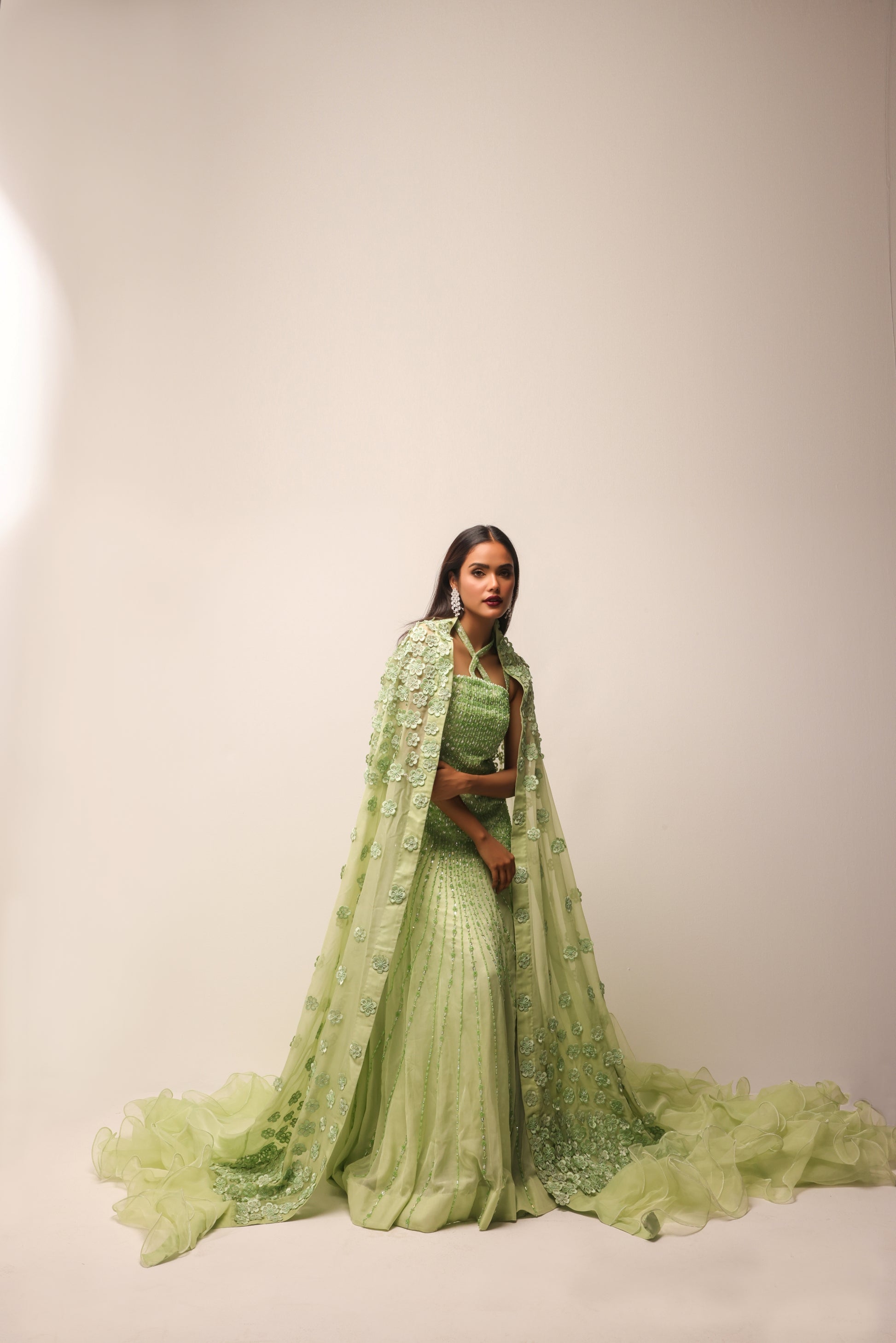 Flowing cape with floral embellishment on designer gown
