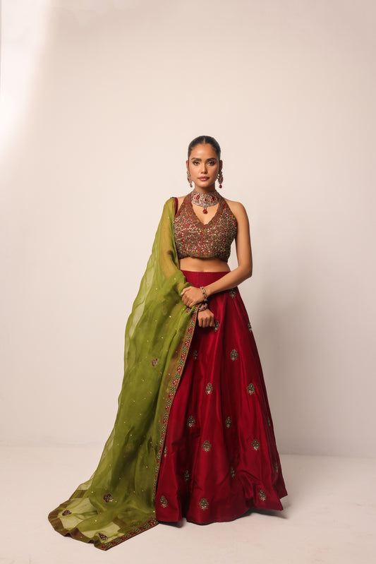 Hand-embroidered red and green bridal lehenga with intricate thread work and stones