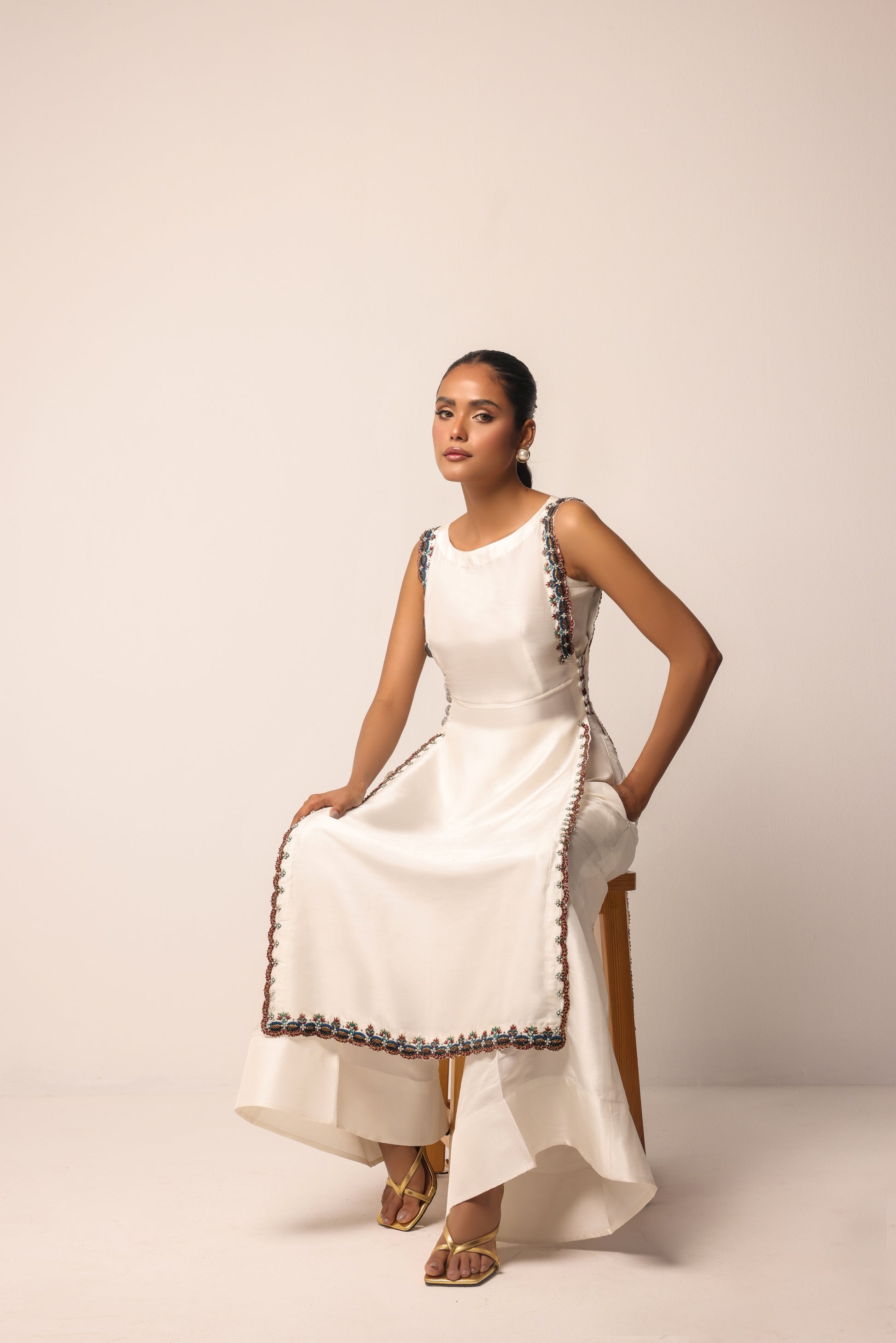 Modern minimalist sleeveless tunic with asymmetrical hemline and intricate detailing