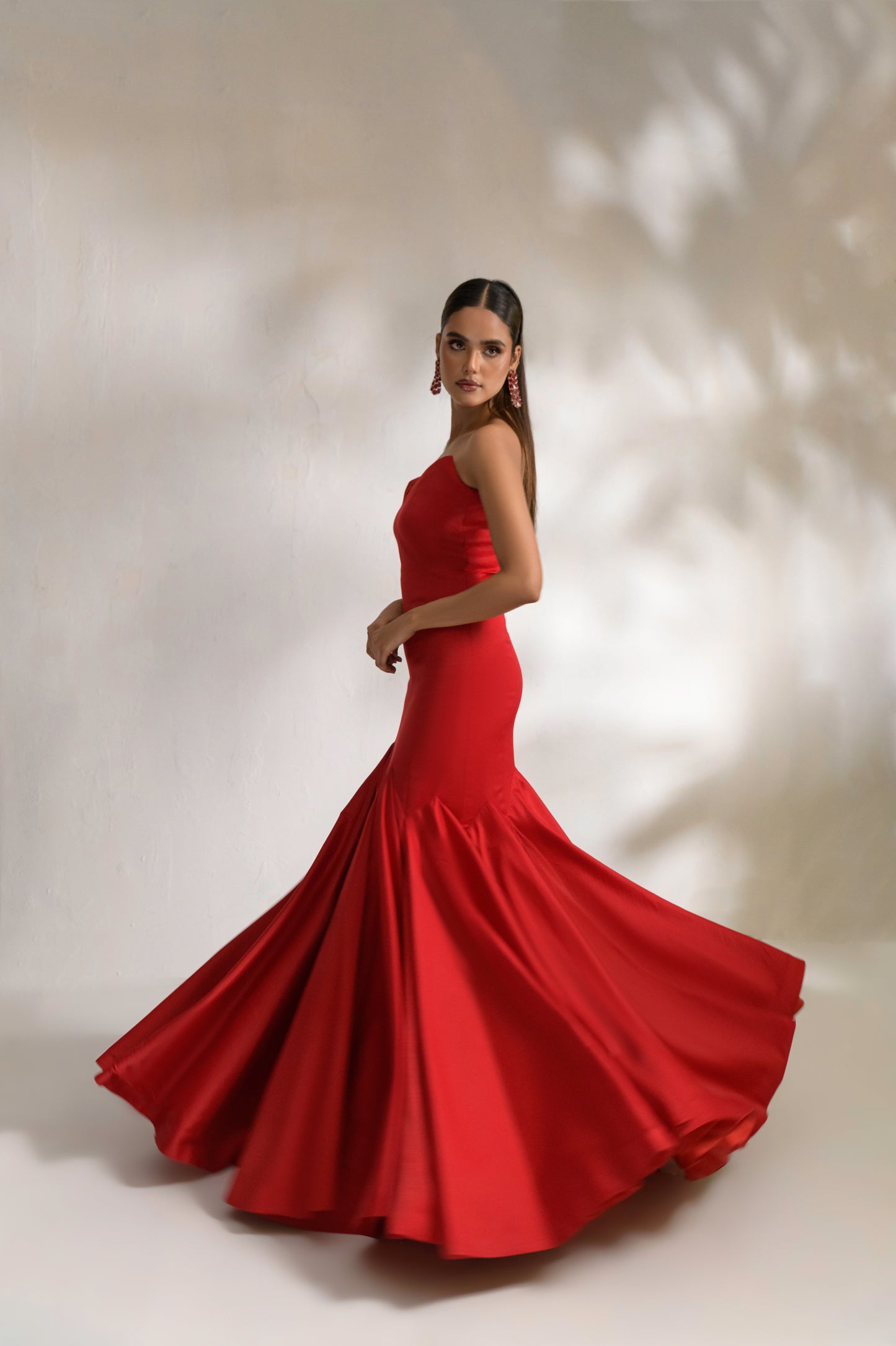 Deep red mermaid gown with body-hugging silhouette and beadwork cape